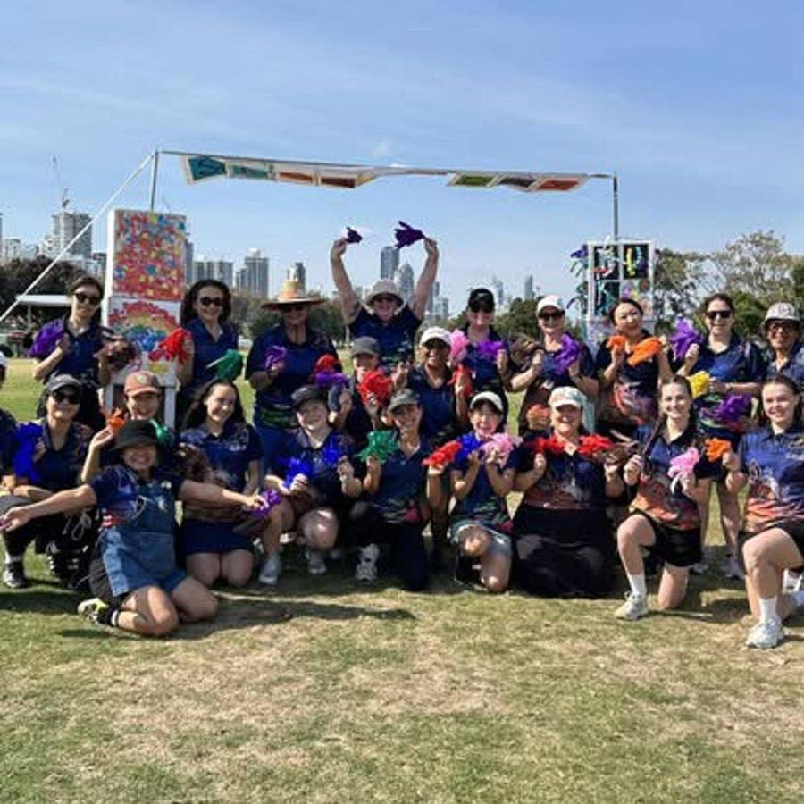 Global Sky Education educators together at our annual Family Sports Day, holding up coloured hand puppets